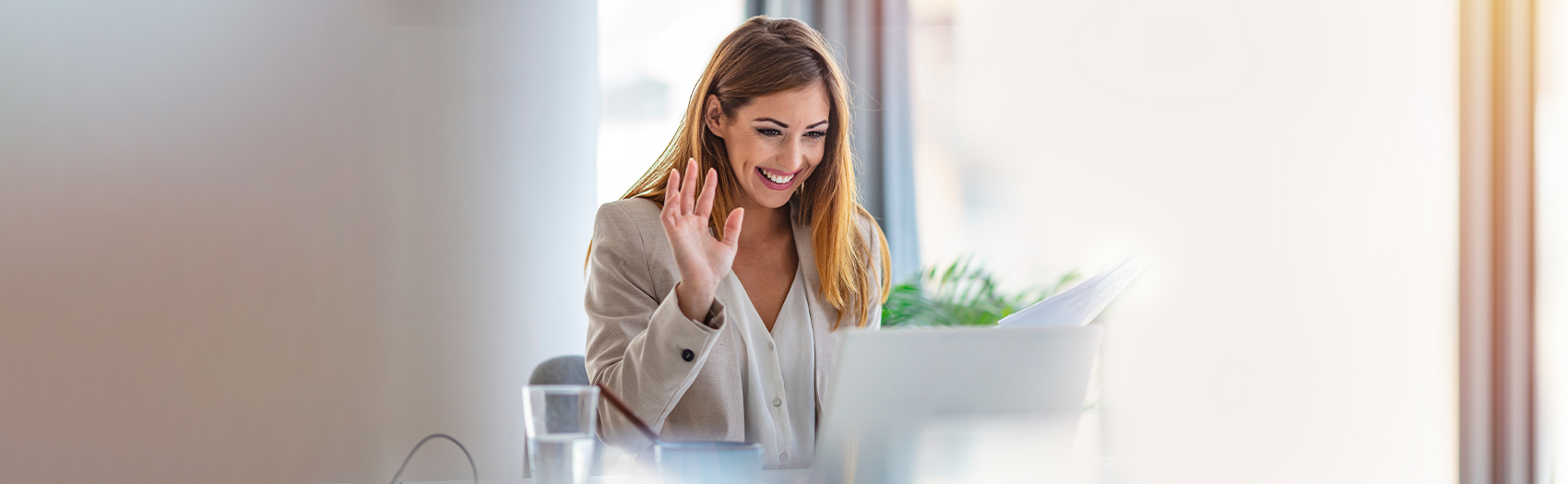 Woman smiling and waving during a video call.