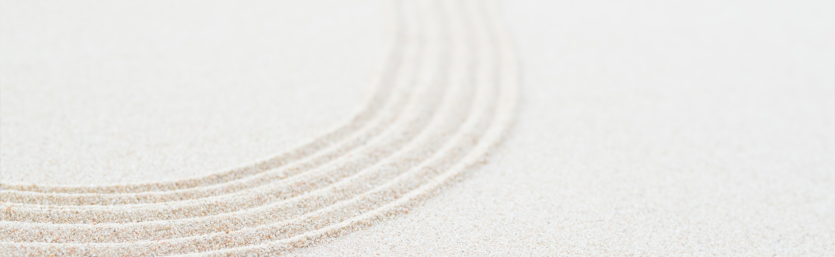Curved lines drawn in white sand.